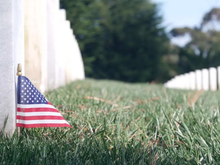 Person Decorating With Military Pictures and Floral Arrangements | Eternally Loved